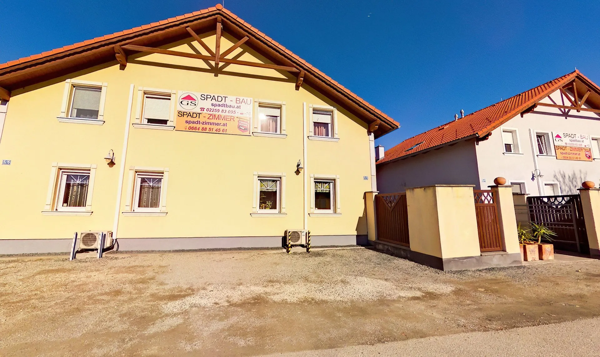 Gästehaus Spadt Zimmer in Münchendorf – Außenansicht mit Parkplätzen vor dem Haus